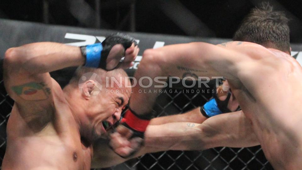 Salah saru petarung di One Fighting Championship 2015 menerima pukulan telak di wajahnya. - INDOSPORT